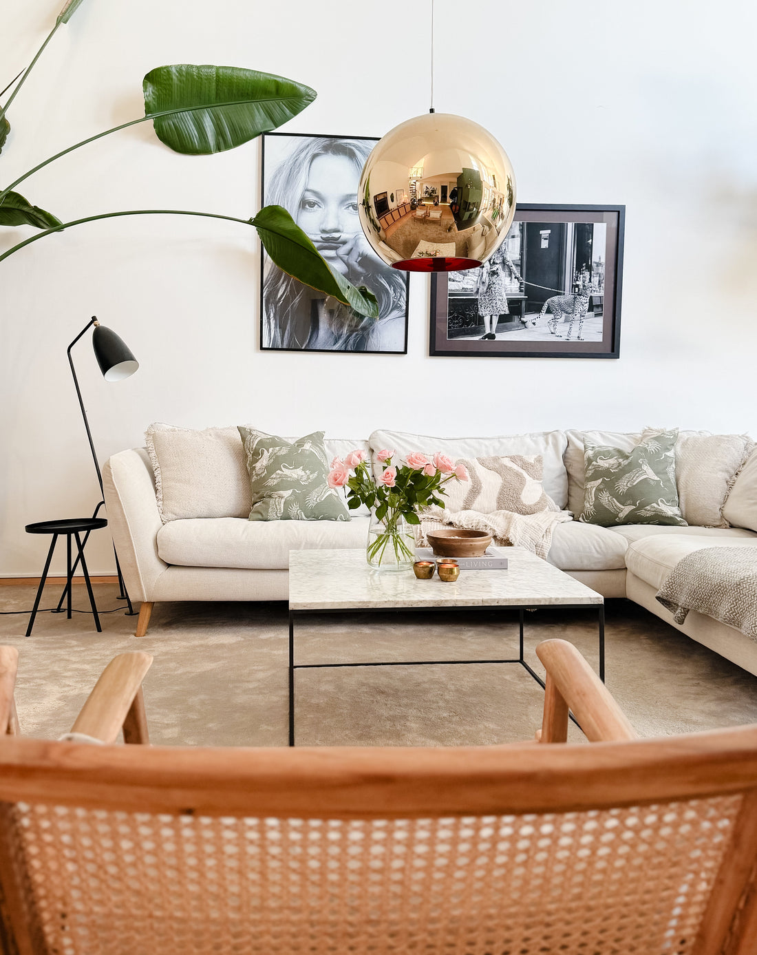 Harmoniskt vardagsrum i neutrala toner med beige soffa, gröna kuddar, marmorbord och stilren skandinavisk inredning